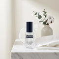 Lifestyle — Melbe Merry Serum on a marble vanity with eucalyptus and cotton, soft morning light